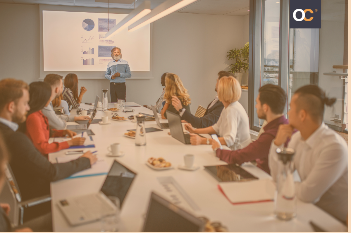 A large group of people in an office, all sitting across the table